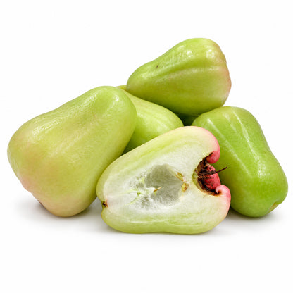 Green Rose Apple cut open to show the flesh on a white background