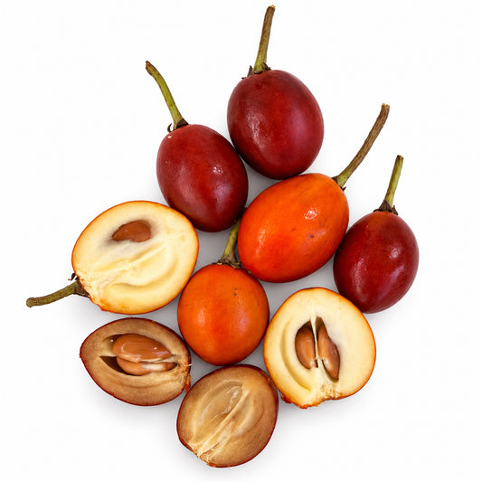 Spanish cherries, whole and cut open to show the flesh and seeds, on a white background