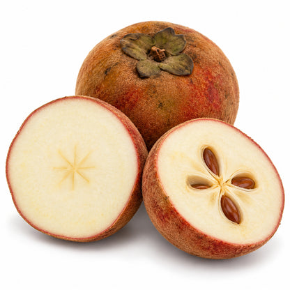 Velvet apple cut open to show pale flesh and brown seeds, with a whole fruit on a white background